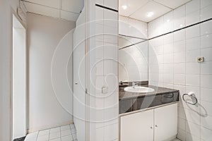 Interior of bathroom in office. Public white restroom with sink, faucet and mirror.