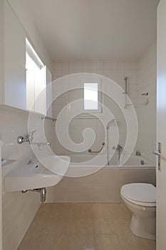 Interior of a bathroom in a small city flat. The toilet, sink and bathtub can be seen