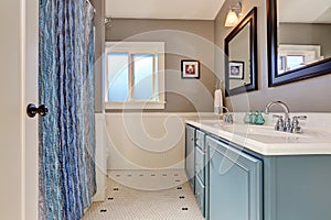 Interior of bathroom with vintage blue vanity cabinet and two sinks