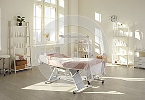 Interior of beauty salon, massage room, or spa centre with massage table and magnifying lamp
