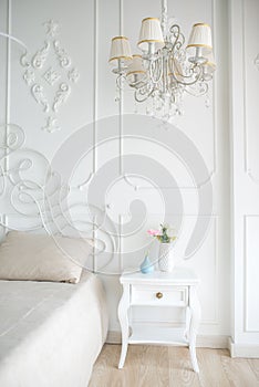 White chandelier in the interior of the bedroom photo