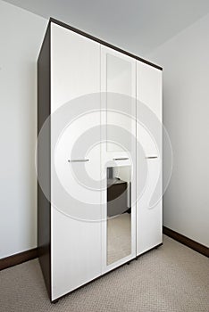 Interior of bedroom with a big white wardrobe