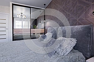 Interior of a bedroom with a large double bed in a modern style in a small apartment