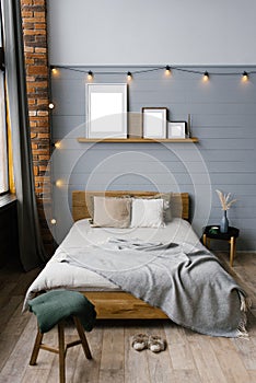 The interior of the bedroom is in the Scandinavian style covered in gray beige brown colors