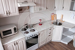 Interior beige small cozy kitchen, cabinets, electric stove