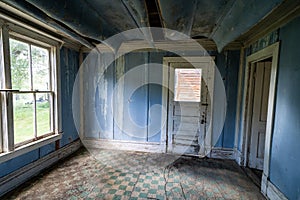 Interior of a blue room, abandoned and decaying, with a rotting floor and collapsing ceiling in Bannack Ghost Town in Montana photo