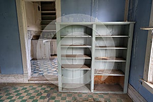 Interior of a blue room, abandoned and decaying, with a rotting floor and collapsing ceiling in Bannack Ghost Town in Montana photo