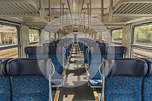 Interior of blue train with blue seat and wooden armrest