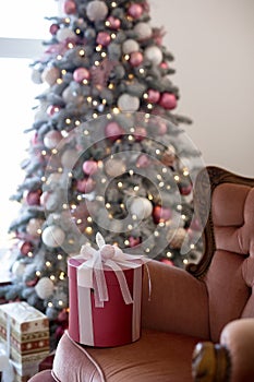 Interior of bright modern living room with comfortable sofa decorated with Christmas tree and gifts