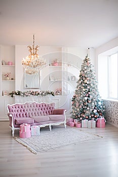 Interior of bright modern living room with fireplace and comfortable sofa decorated with Christmas tree and gifts