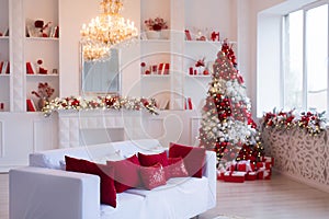 Interior of bright modern living room with fireplace and comfortable sofa decorated with Christmas tree and gifts