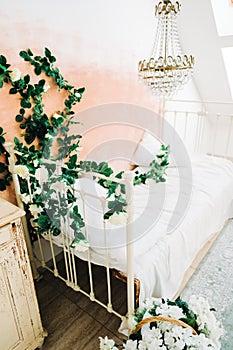 Interior of bright white bedroom with decorative flowers on a wall