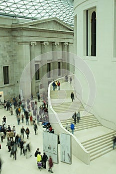 the interior of the British Museum in London showing the atrium roof and visitors blurred with movement