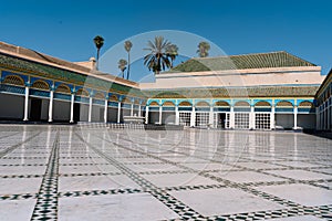 Interior of a building with a courtyard build with mosaics on the floor and an interior fountain surrounded by columns with arches