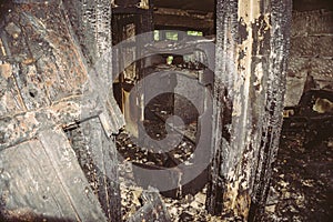 Interior in a burnt house, burnt charred wooden doors