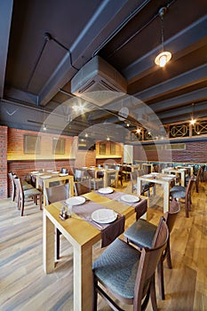 Interior of cafe with wooden furniture and walls