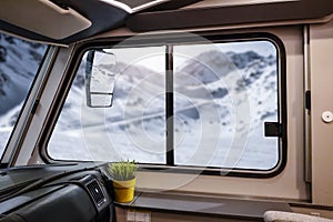 Interior of camper with big window winter view. Empty space for your decoration. Cold december day and landscape of mountains.