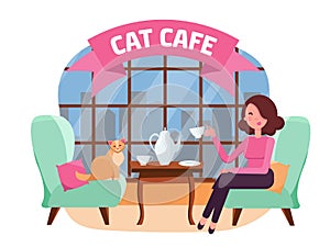 Interior of cat cafe with large window, woman and Kitty in comfortable armchairs. Girl and cat Tea party. Spending time with pet.