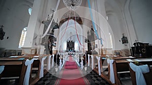 The interior of a Catholic church with white balloons before the church service.
