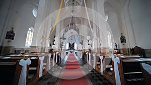 The interior of a Catholic church with white balloons before the service.