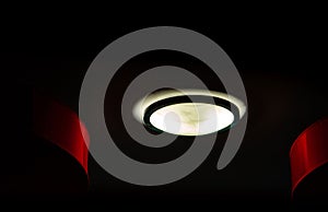 Interior ceiling lights on dark background at night. Interior lighting concept. Round glass with black ring cover ceiling lamp