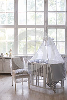 Interior of the children`s room, Provence style, oval baby cot, with canopy, light interior, large beautiful window