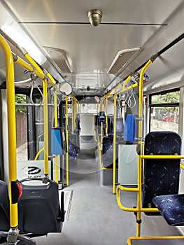 Interior of a city bus. Empty bus interior. Bus with blue seats and yellow handrails. Public transport in the city of Cluj Romania