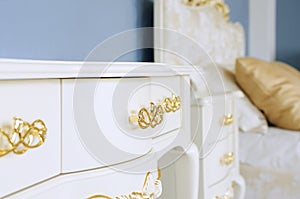 Interior in classic style. Luxurious white furniture with golden handles