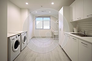 Interior clean white laundry room with front load washer and dryer units.