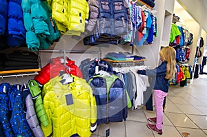 Interior of a clothing store for children. Young girl shopping