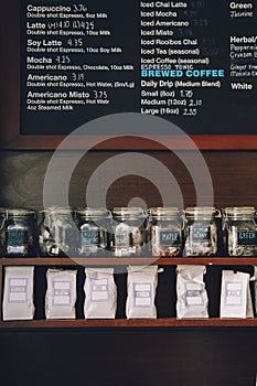 Interior of coffee shop. Wooden board with names of coffee hot and cold drinks, prices.