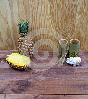 Interior composition of a home on wood table or floor and wall. Handmade white elephant aroma candle. Tropical fruit fresh pineapp