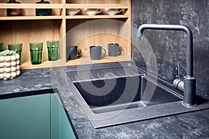 Interior of contemporary green and red kitchen. Luxury modern fitted flat design kitchen with square stoneware sink and
