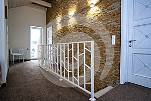 Interior of a contemporary home with spacious hallway, room doors and staircase railing in modern style