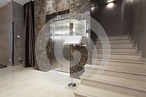 Interior of a corridor with passenger lift and marble stairs