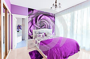 Interior of cozy bedroom in bright violet tones. Large mirrored