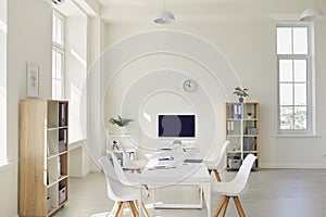 Interior of cozy light boardroom with big table, modern chairs and desktop computer