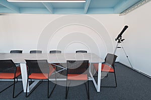 Interior of cozy light boardroom with table, modern stylish chairs and desktop computer, all ready for corporate meeting