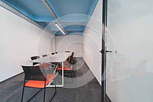 Interior of cozy light boardroom with table, modern stylish chairs and desktop computer, all ready for corporate meeting