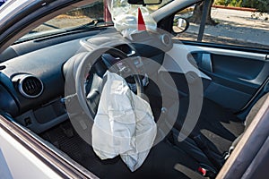 Interior of crashed car after accident with deflated airbags on photo