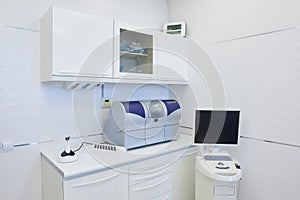 An interior of a dental office with white and blue furniture. Dentistâ€™s office
