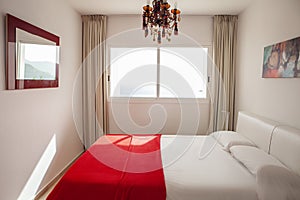 Interior design in bedroom of pool villa with cozy king bed. Bedroom with red and white colors