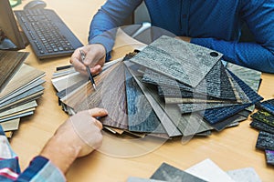 Interior design - customer choosing floor material from samples at flooring shop