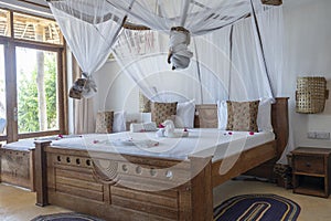 Interior design decor furnishing of luxury show home holiday villa bedroom with four poster bed. Interior design of the tropical