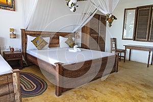 Interior design decor furnishing of luxury show home holiday villa bedroom with four poster bed. Interior design of the tropical