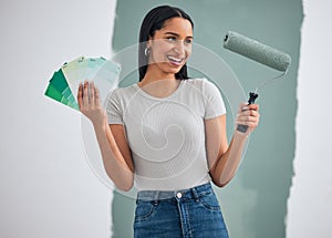 Interior design, green paint and woman doing home renovation with paintbrush roller and color cards in hand. Decoration