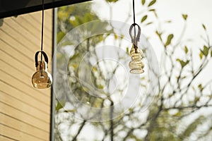Interior design of lamp. A LED light bulb is illuminating and hanging under a house roof. Lighting lamp under the ceiling.
