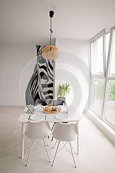 Interior Design of a Light Dining Room in a Minimalist Style with a Square Wooden Server White Table, Black and White