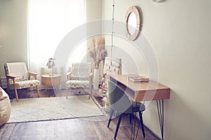 Interior design of the living room with a copy space, two armchairs. A writing table, dried flowers. Beige walls