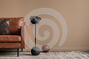 Interior design of living room interior with copy space, brown sofa, black coffee table, patterned pillow, gray rug, brown ball